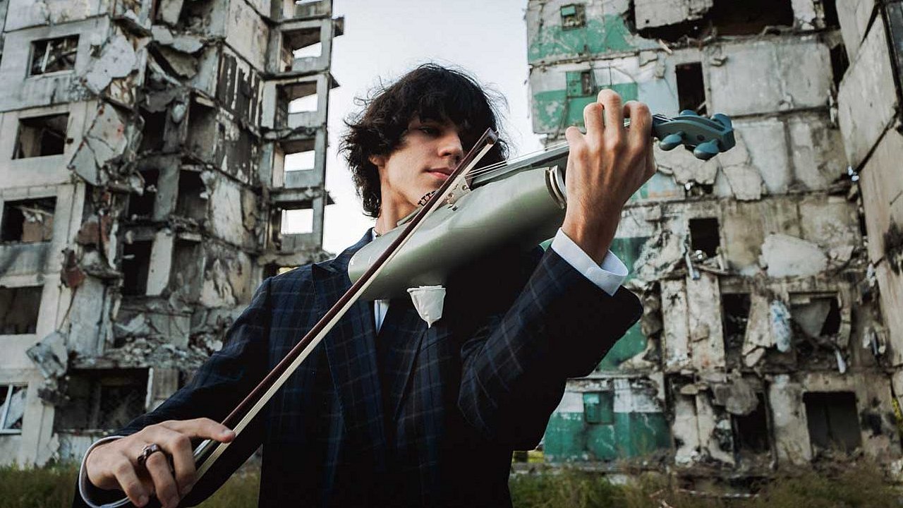 Junger Mann spielt auf einer Geige, die aus einem Raketenkopf gebaut wurde