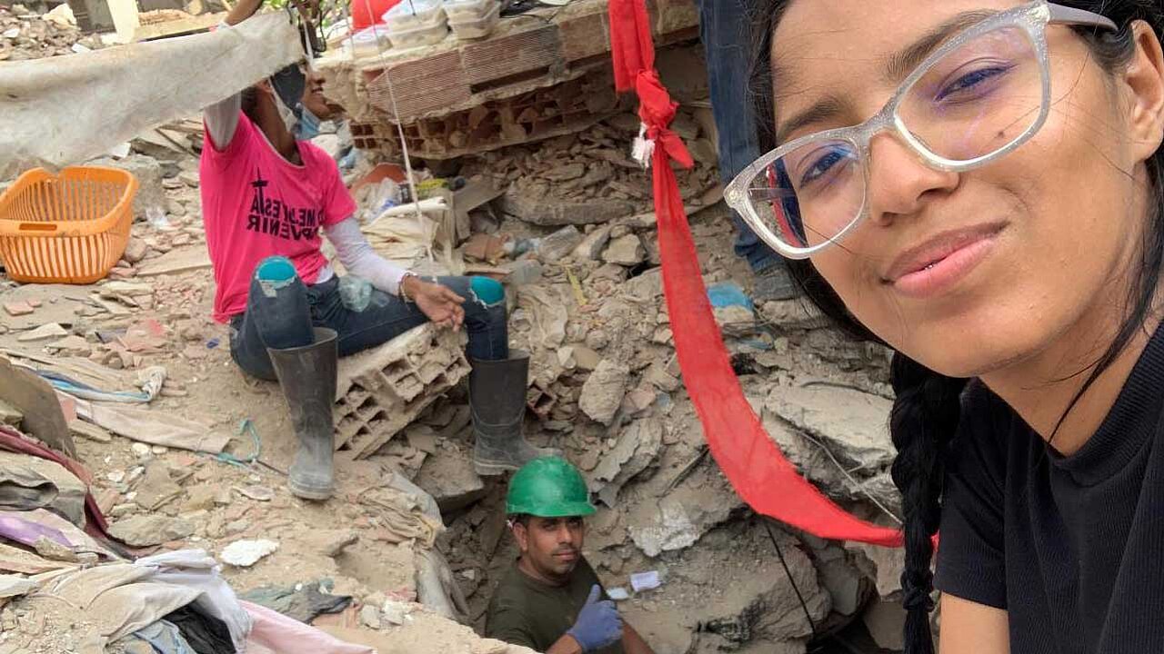 Sabrina Pérez (vorne im Bild) sucht gemeinsam mit Nachbarn (2 Männer im Hintergrund) in den Trümmern nach Überlebenden.