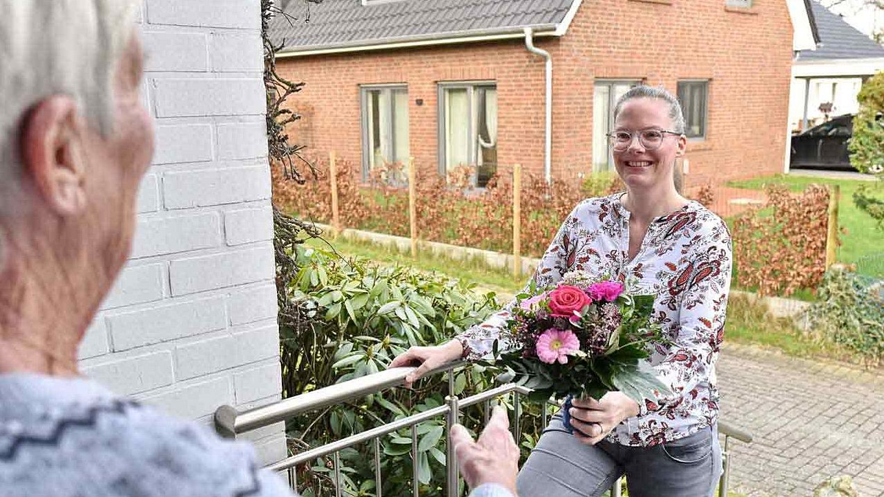 Eine Frau überreicht einen Blumenstrauß