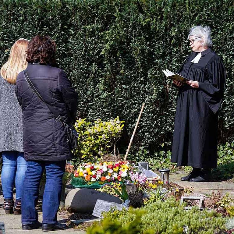 Beerdigung in Corona-Zeiten: Eine Andacht im Freien vor der Urnenbeisetzung auf dem Gemeindefriedhof in Essen-Haarzopf mit Pfarrerin Elisabeth Müller. Nur wenige Angehörige dürfen teilnehmen.