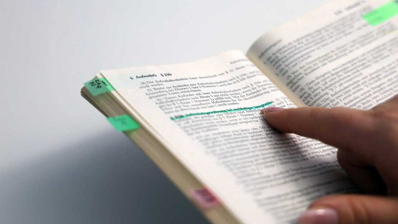 Das aufgeschlagene Aufenthaltsgesetz. Im Text mit grünem Highlighter markiert: Paragraph 25b: Aufenthaltsgewährung bei nachhaltiger Integration