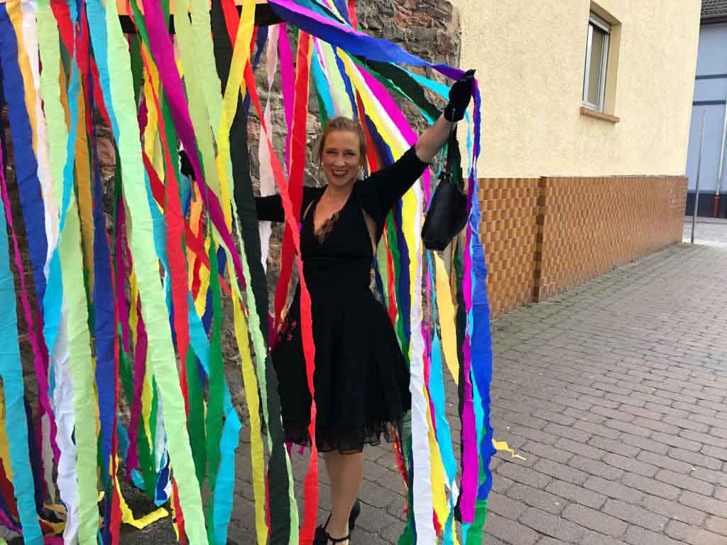 Die Kunstinstallation Walzer von Pirkko hat viele bunte Streifen, die von einem Gestell gehalten werden. 