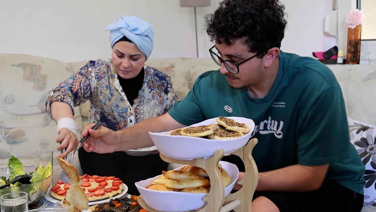Ilham Khaskiyeh und ihr Sohn Mohammed essen.