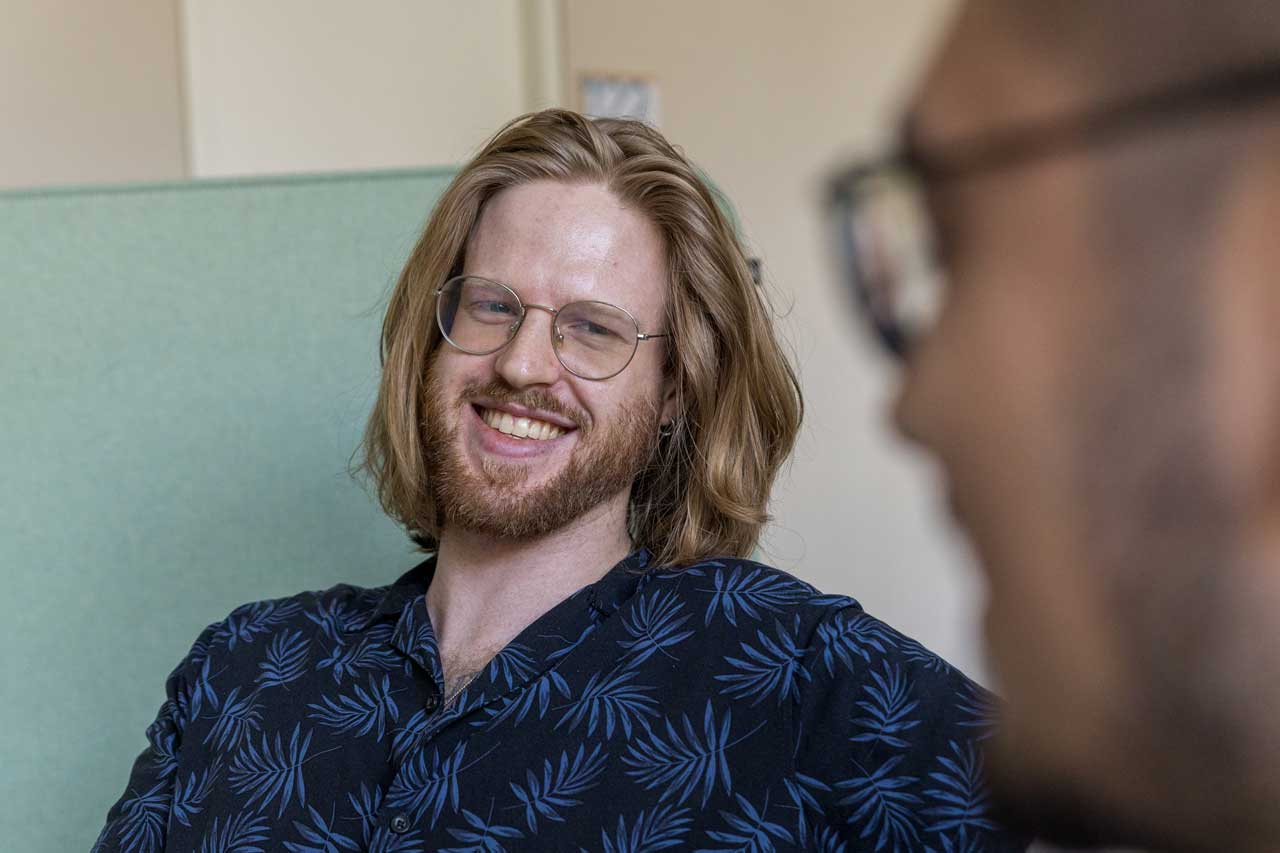 Kiril und Furkan im Gespräch. Die Kamera fokussiert Kiril, während Furkan unscharf im Profil zu erkennen ist.