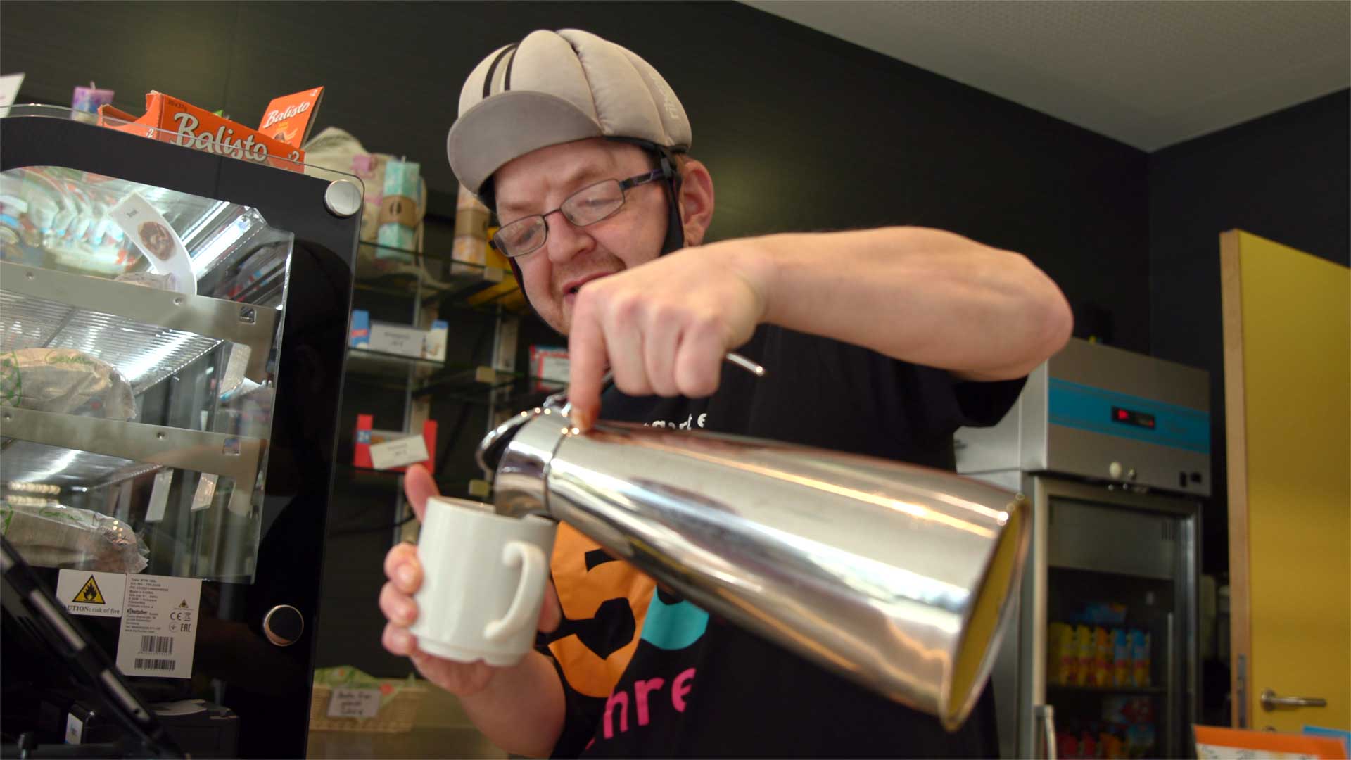 Christian Sulzberger schenkt aus einer Thermoskanne Kaffee in einen Pott. 