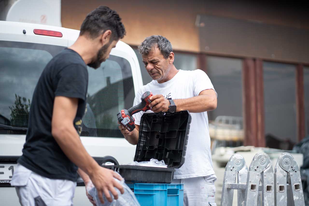 Fahad Alkhatib räumt zusammen mit seinem Mitarbeiter das Werkzeug zusammen. Die beiden stehen draußen vor dem Wagen. 