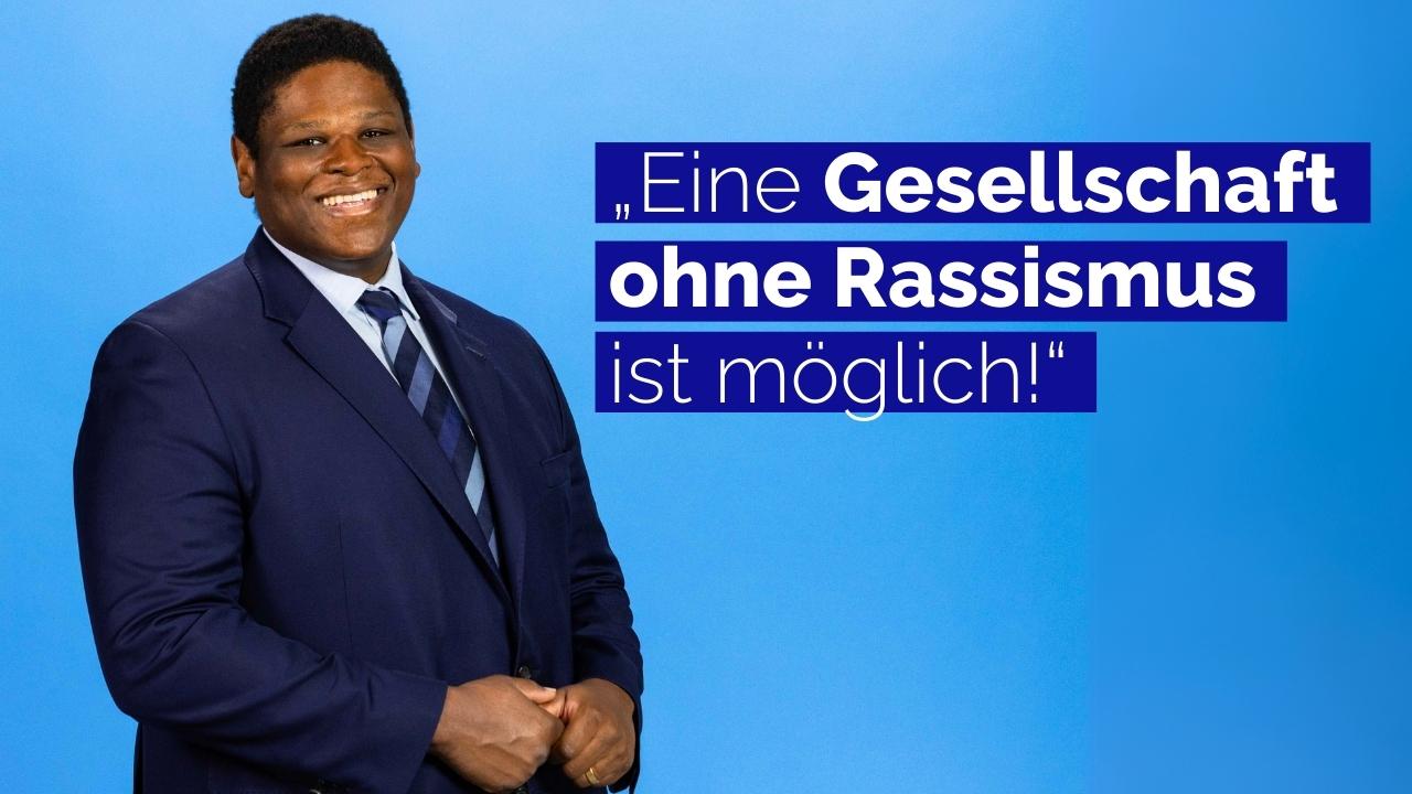 Lorenz Narku Laing lächelt in die Kamera. Dazu das Zitat: „Eine Gesellschaft ohne Rassismus  ist möglich!“