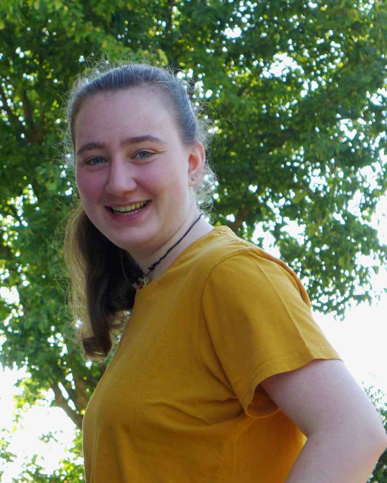 Jasmin im gelben Shirt lächelt