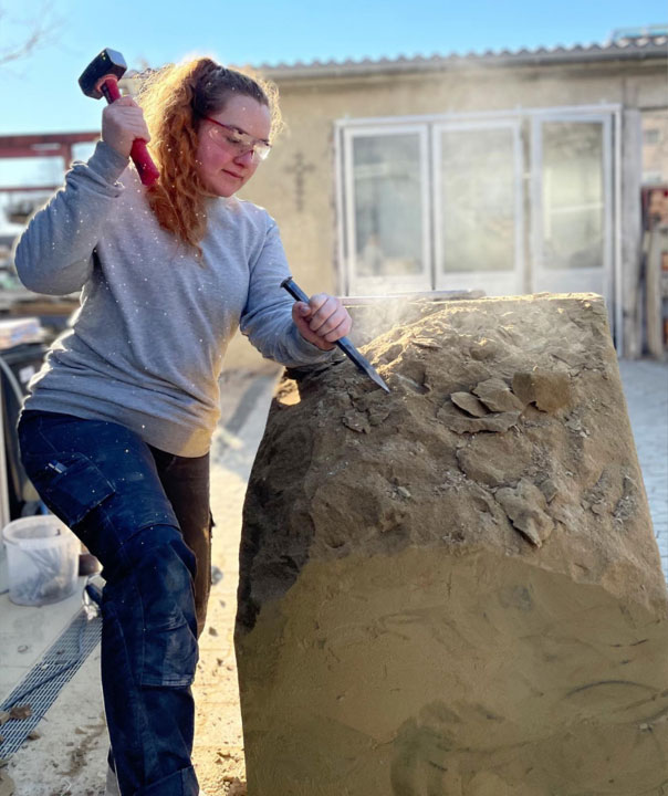 Luisa Lüttich bei Steinmetzarbeiten außen