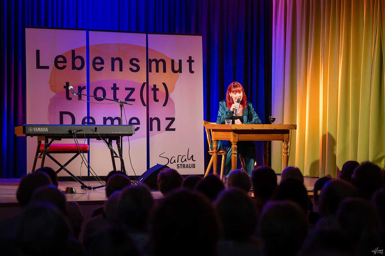 Sarah auf der Bühne bei einer Lesung von ihrem Buch „Lebensmut trotz Demenz“.