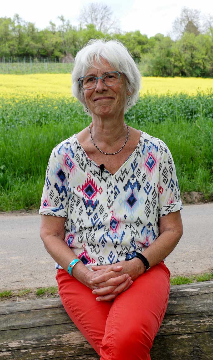 Trauerbegleiterin Heidi Naumann sitzt auf einem Stamm