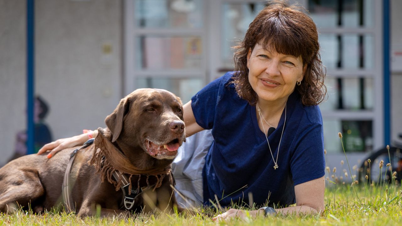 Gemeindepädagogin Claudi mit ihrem Hund Samu vor der Kita