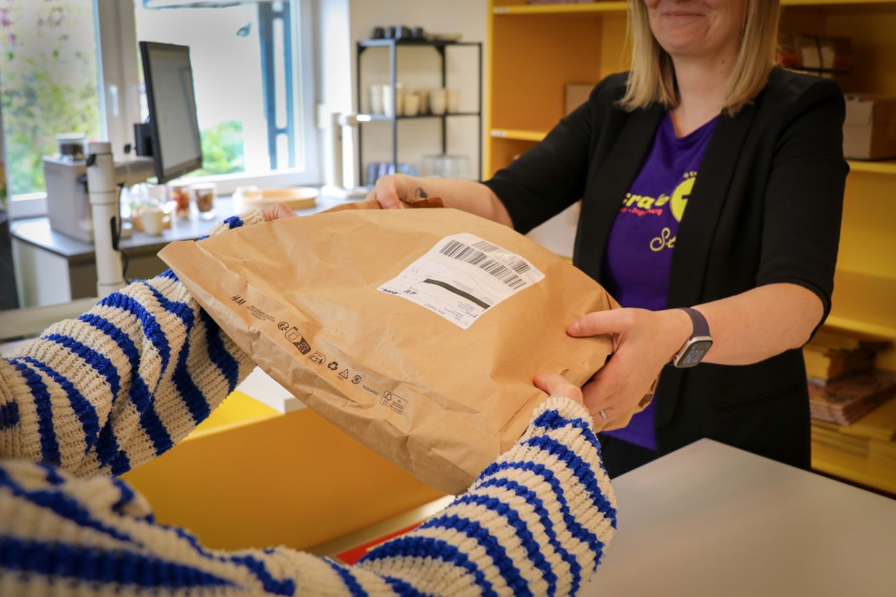 ein Paket wird in der Postfiliale übergenen