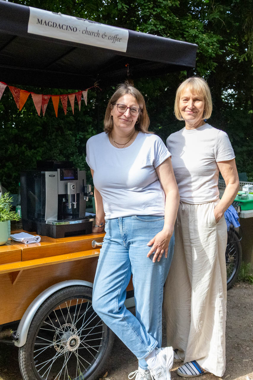 Zwei Frauen stehen an einem großen Lastenfahrrad, auf dem eine Kaffeemaschine steht