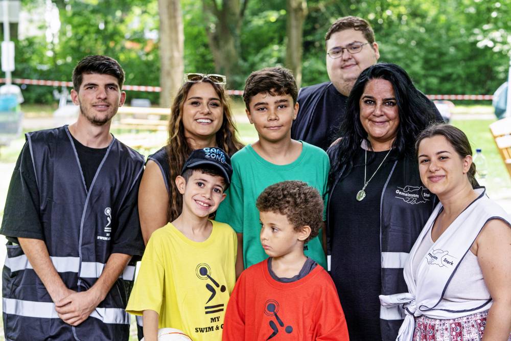 Eine Gruppe aus Kindern, jungen Frauen und Männern lächelt in die Kamera