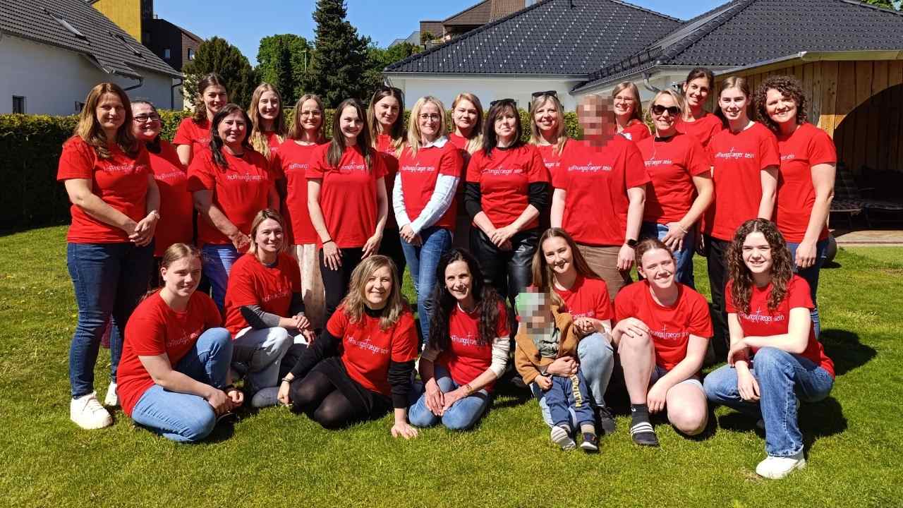 26 Frauen sind auf einem Gruppenfoto zu sehen. Sie tragen alle ein rotes T-Shirt mit dem Aufdruck "Hoffnungsträger sein".