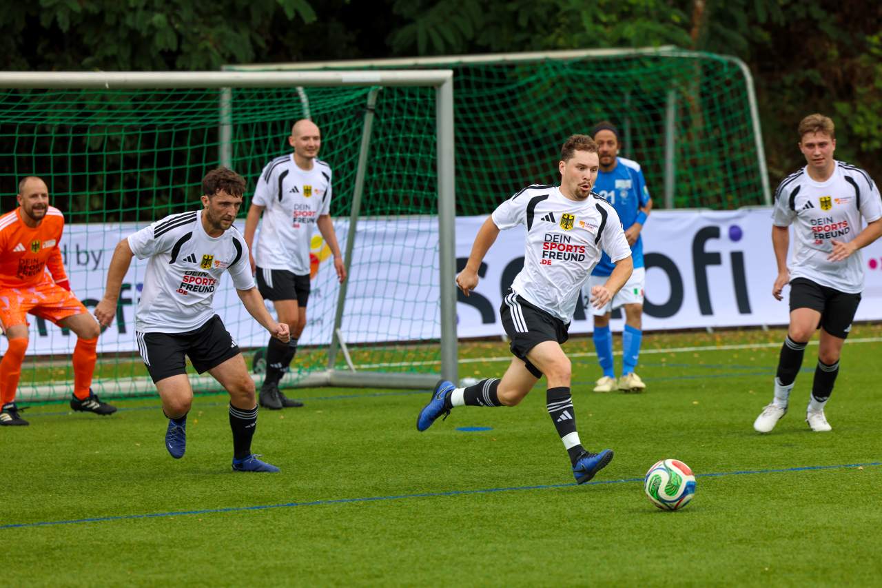 vier Deutsche rennen hinter dem Ball her