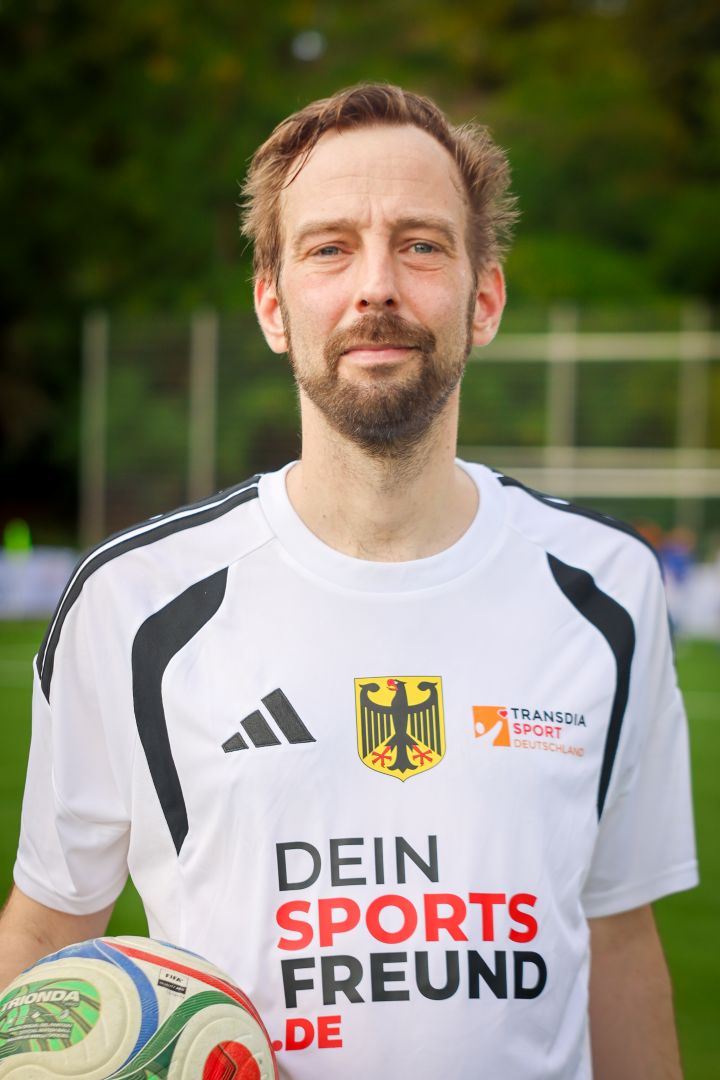 Lars Weddig steht mit Trikot und Ball in der Hand auf dem Fußballplatz