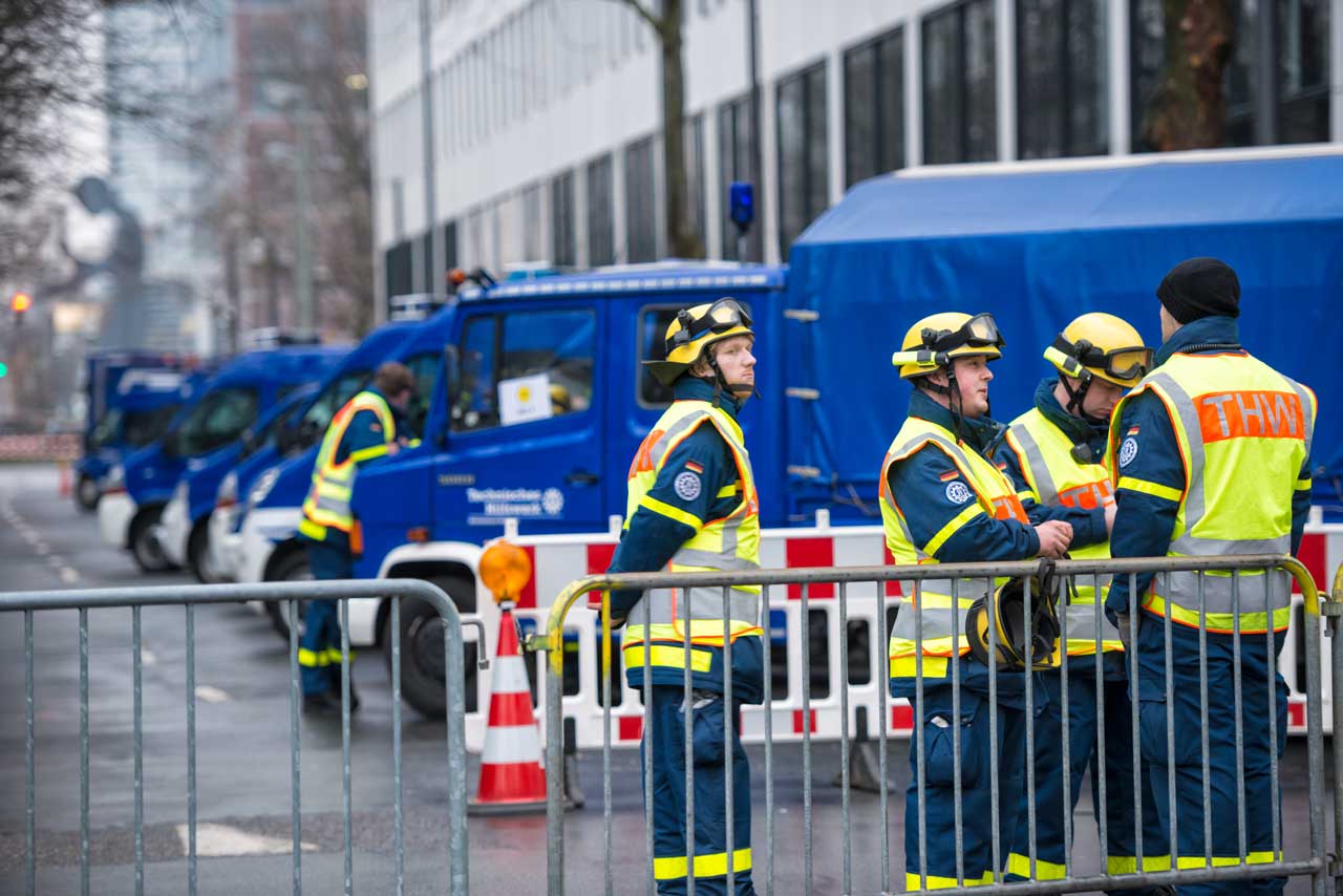 Mitglieder des THW vor ihren Gerätefahrzeugen. 