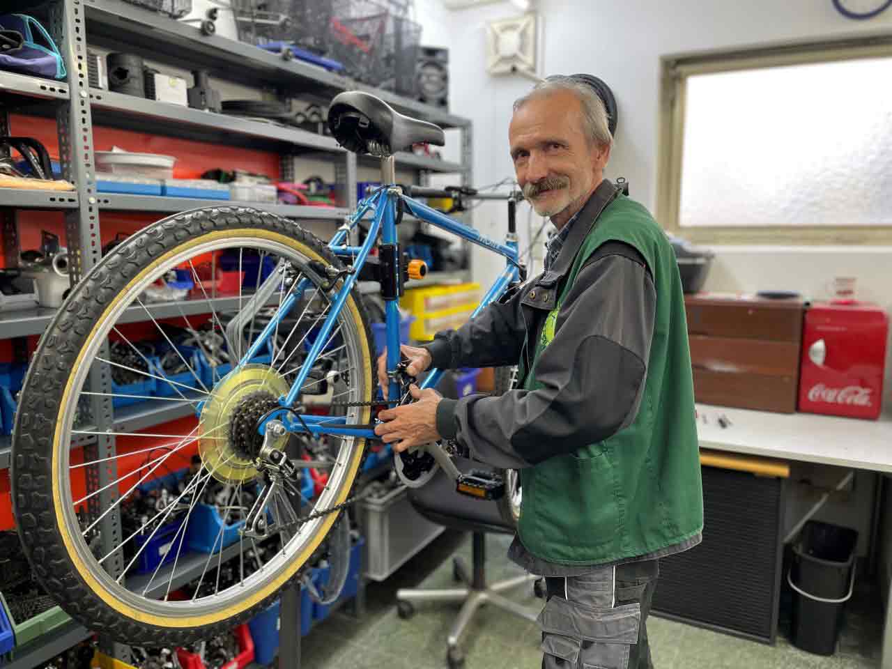 Älterer Herr repariert Fahrrad.