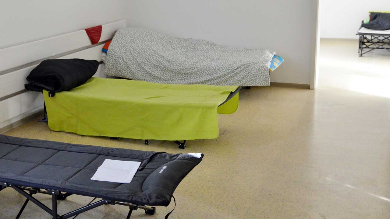 3 Feldbetten in einem Raum der Notunterkunft