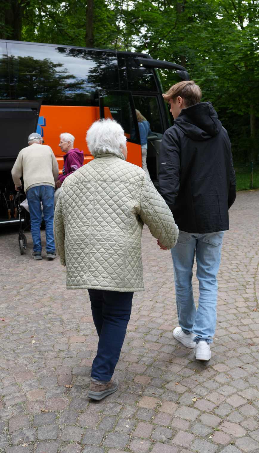 Reporter bringt Bewohnerin zum Bus. 