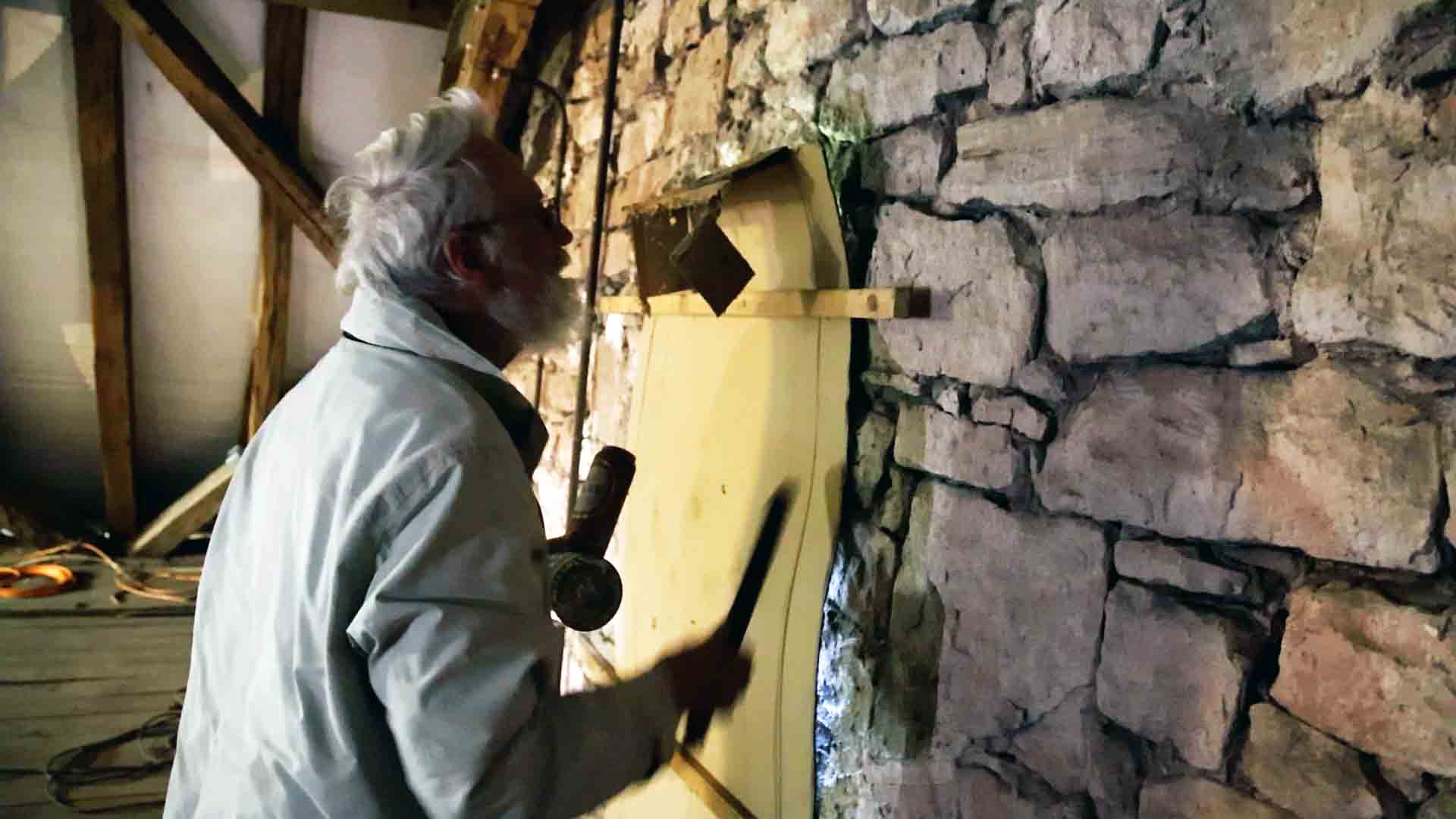 Rudolf Wild sieht sich ein verdunkeltes Fenster an