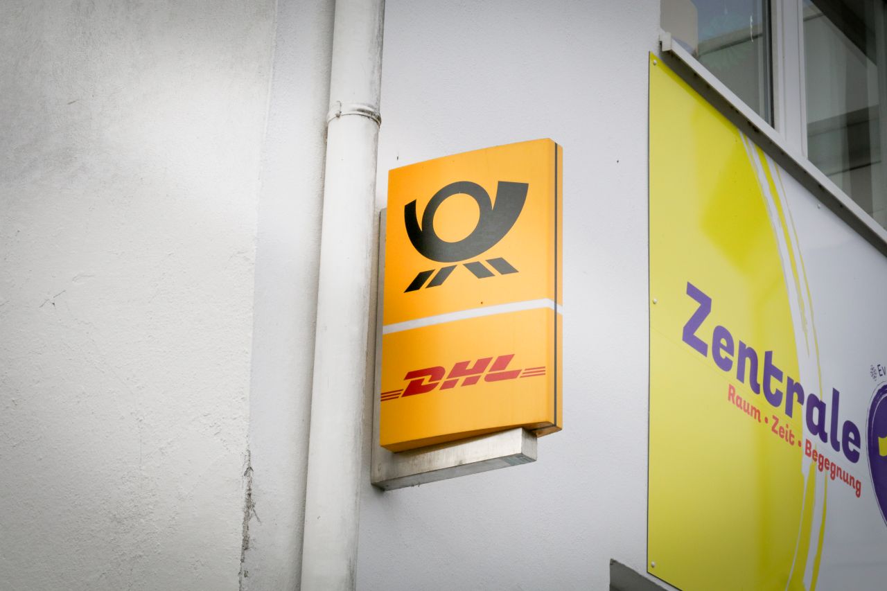 leuchtendes Postlogo an einer Hausfassade