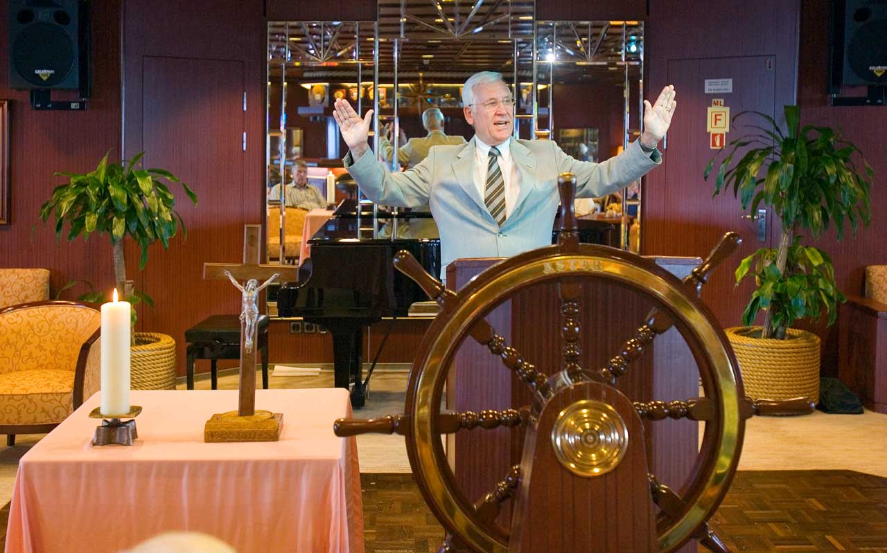 Morgenandacht mit Bordseelsorger Arthur Stenzel im Captain's Club auf dem Promenadendeck. Er segnet die Besucher des Gotttesdienstes.