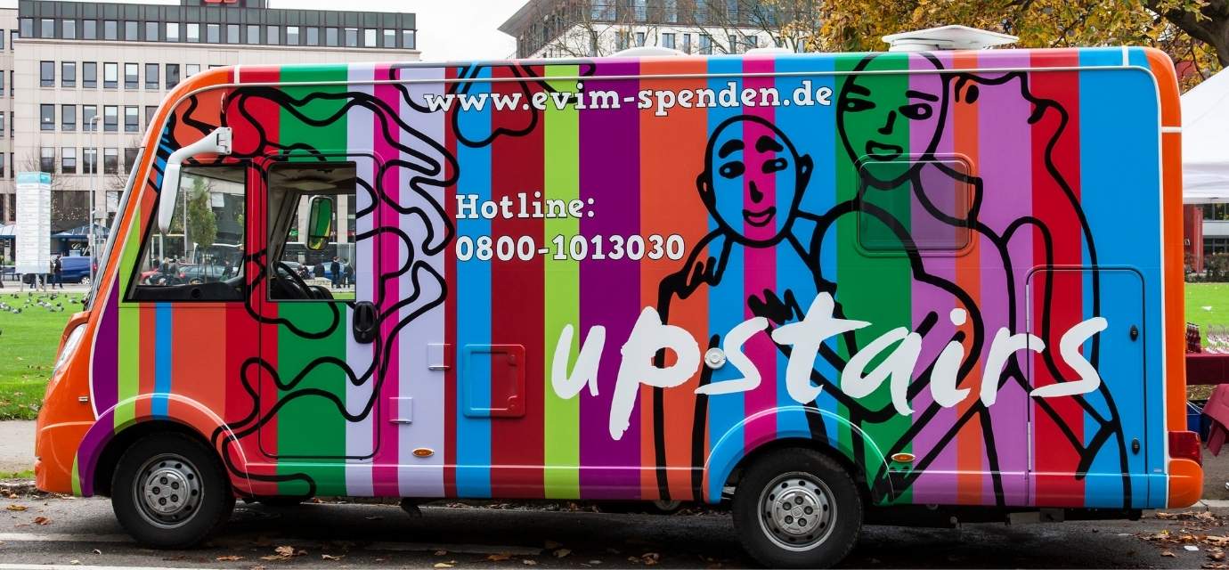 Der bunte Bus von upstairs ist von der Seite abgebildet. 