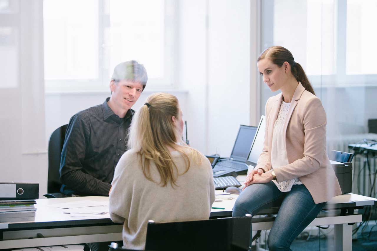 3 Personen im Büro im Gespräch