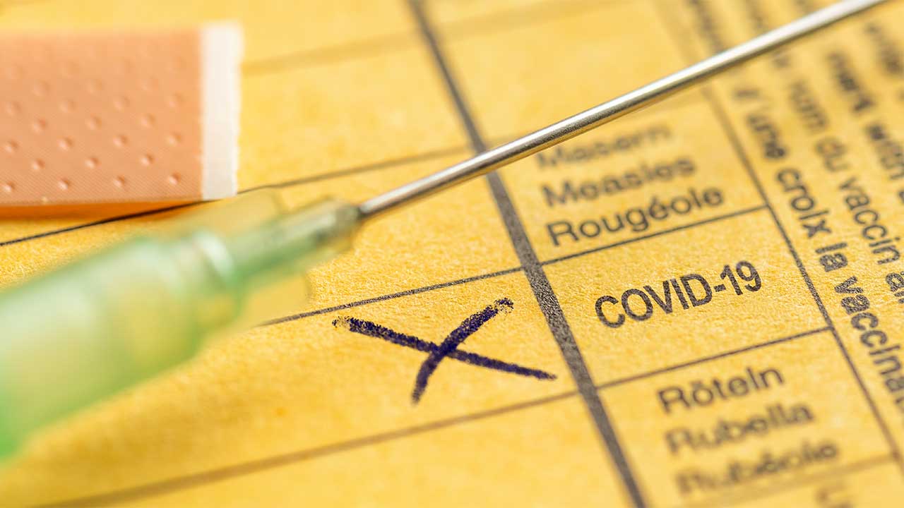 Ein Impfpass mit Impfung auf COVID-19