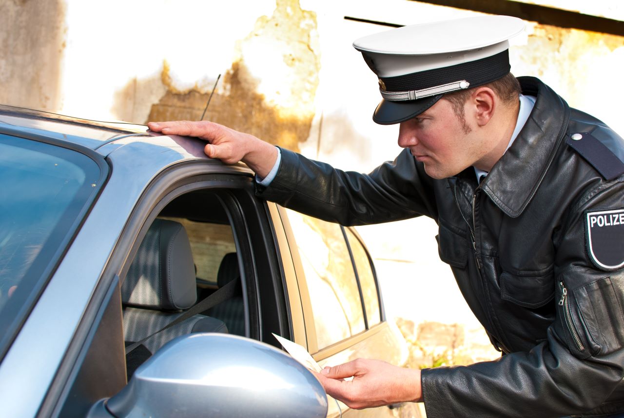 Ein Polizist kontrolliert einen Autofahrer.