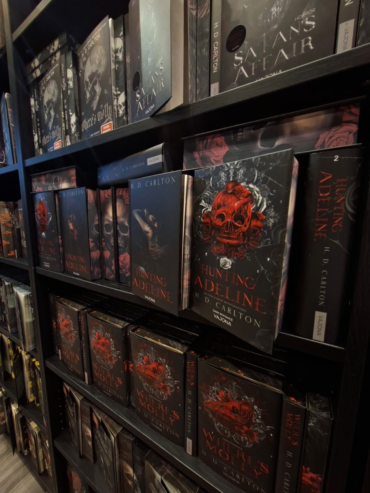 Viele Dark Romance Romane in einem Regal, darunter Haunting Adeline