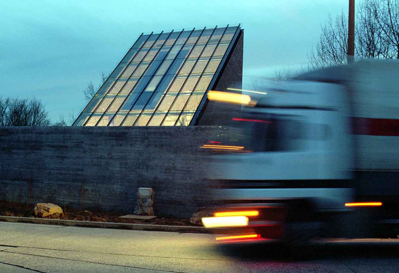 Das Dach der Autobahnkirche und im Vordergrund ein LKW, der vorbeifärt.