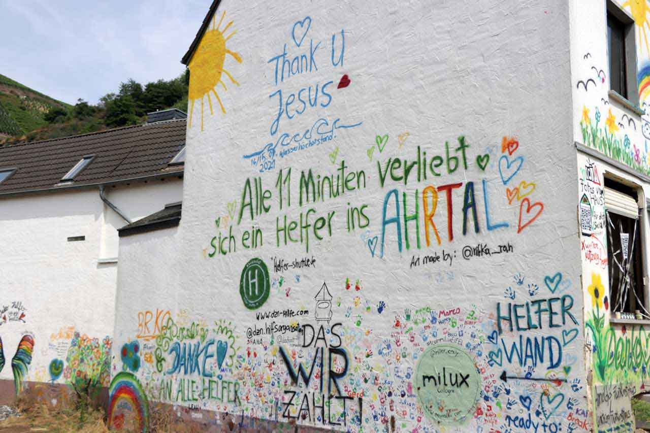 Graffitis an einer Hauswand. u.a.: Alle 11 Minuten verliebt sich ein Helfer ins Ahrtal