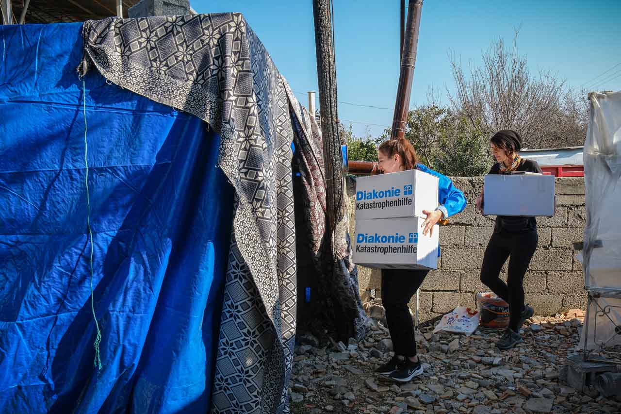 Bilge Menekşe von der Diakonie Katastrophenhilfe übergibt Hygieneboxen für Erdbebenopfer im Buyuk Dalyan Distrikt von Hatay