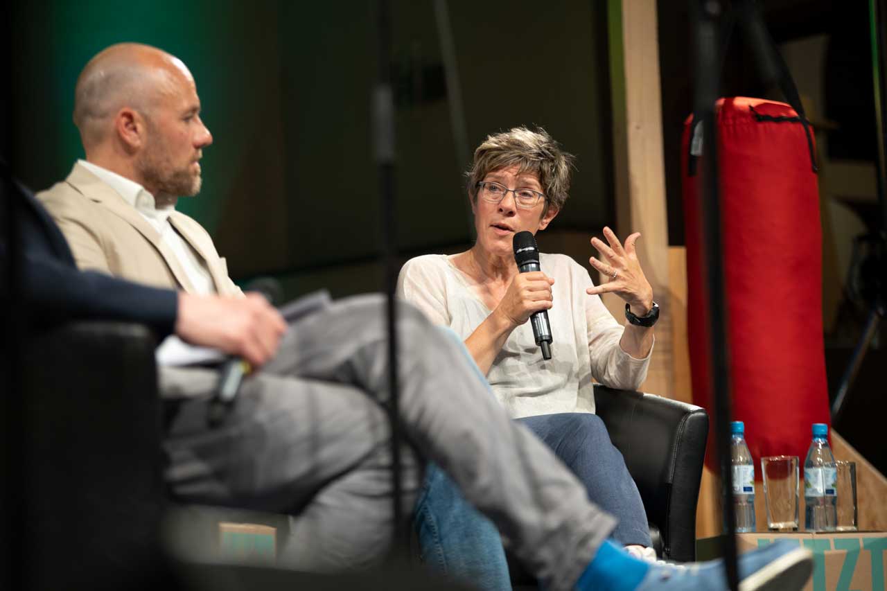 Annegret Kramp-Karrenbauer auf dem Podium in einem Sessel sitzend.