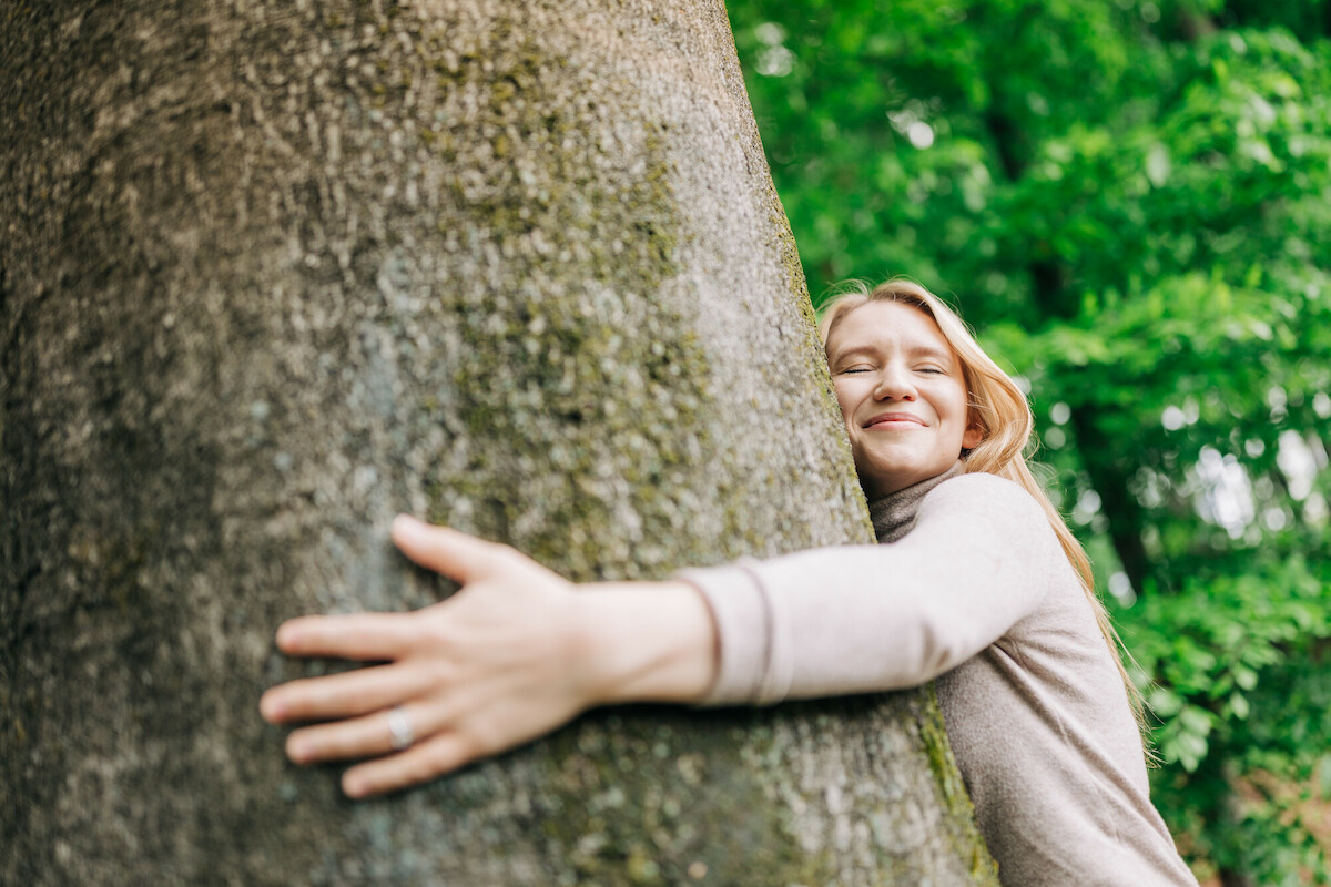 Frau umarmt einen Baum